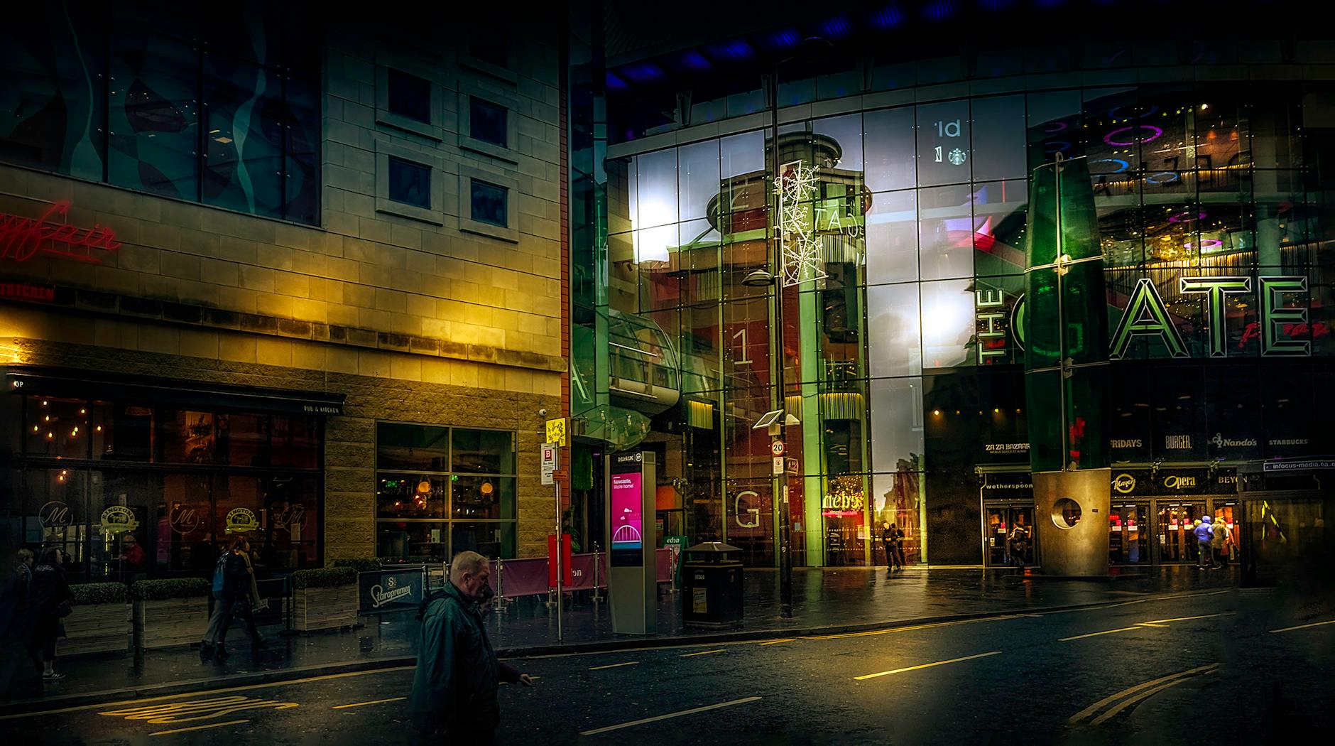 photo of shops on city buildings along the street at nighttime